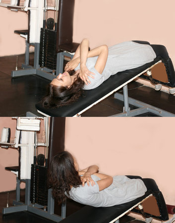 Workout fitness exercises in the gym on the simulator for the press. Gymnastics for the press.