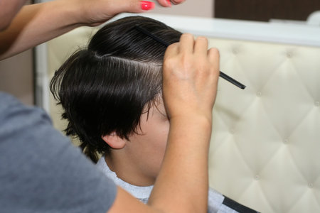 Haircut of a boy at the hairdresser. Trimer