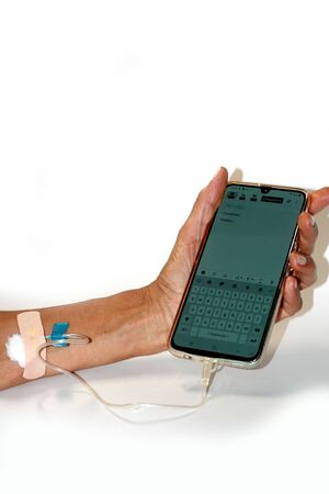 Smartphone dropping medicine. A dropper in a man handの写真素材