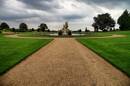 Witley Court fountain with statue. Green grass and trees. Dramatic clouds.のeditorial素材
