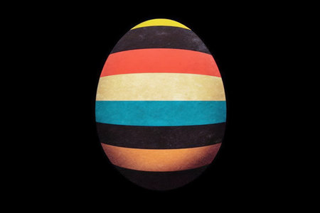 Colorful painted easter egg on a black background with copy spaceの素材