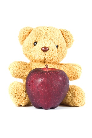 bear doll give fresh red apple on whiteの写真素材