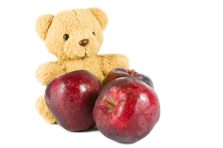 bear doll give fresh red apple on whiteの写真素材