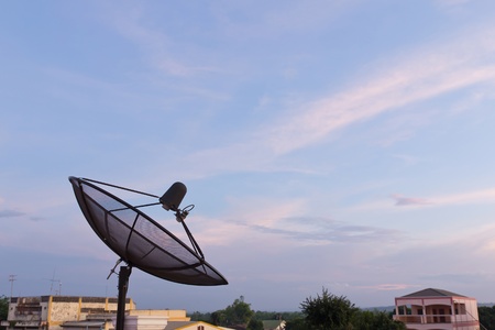 Black satellite dish in community on blue sky backgroundの写真素材