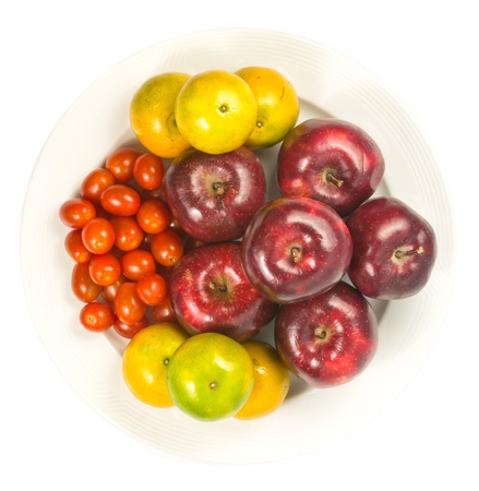 apple, orange, tomato on dishの写真素材