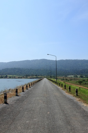local road beside a dam in mountainの写真素材