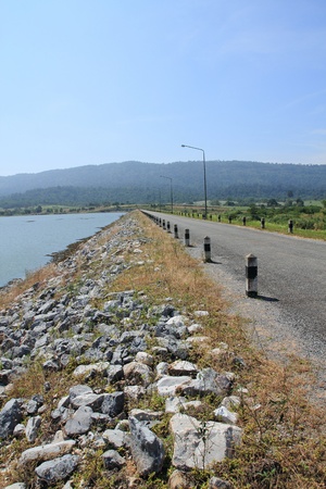 local road beside a dam in mountainの写真素材