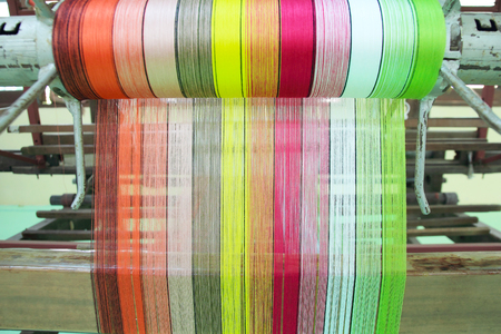 Colorful yarn pattern is set up on the loom bench and ready to weave.の写真素材