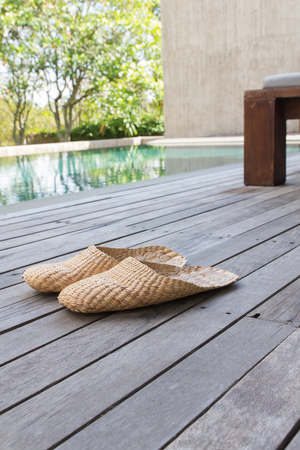 Vintage slippers handmade with bamboo on wood floorの写真素材