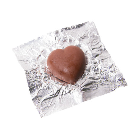 Chocolate heart candy in foil on white backgroundの写真素材