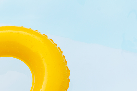 Close up yellow ring floating in refreshing blue swimming pool.の写真素材