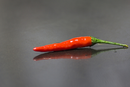 A Hot Chilli Peppers on black granite table background.の写真素材