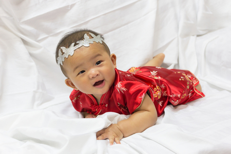 Asian cute new born girl baby with gesture of congratulation happy chinese new yeras.の写真素材