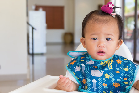 Asian cute baby standby on chair kid for feeding time.の写真素材
