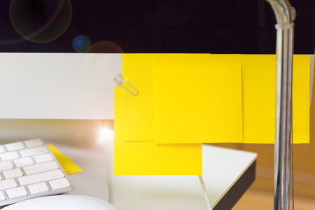 Empty yellow sticky note on computer, work business desk.の写真素材