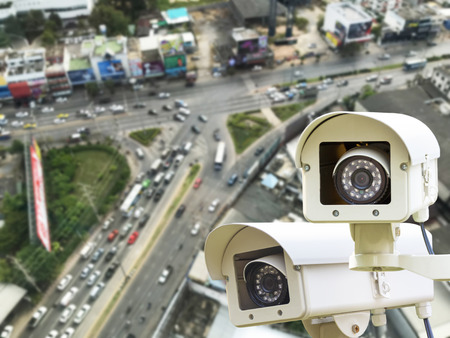 The CCTV Security Camera operating on traffic road blur background.の写真素材