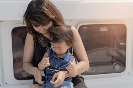 Asian cute baby girl and beautiful mother enjoying on luxury yacth background, family lifestyle concept.の写真素材