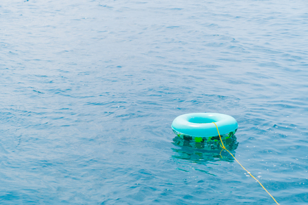 Green fashion ring life on sea water background.の写真素材