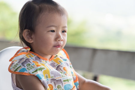 Close up Asain cute baby girl eatting ice water on white chair.