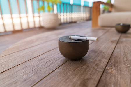 Cigarette burning on wood table background.の写真素材