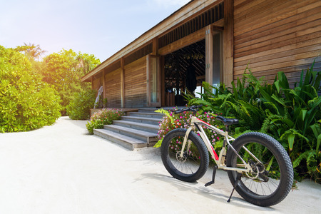 Bike on the beach, with resort background.の写真素材