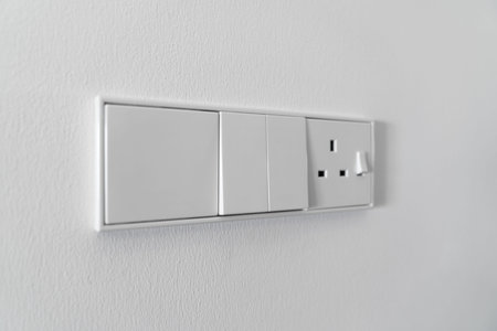 Modern white switch on white wall background.