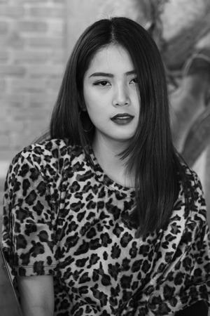 A beautiful woman portrait. Asian teenager concept, with tiger line shirt in the vintage cafe.の写真素材