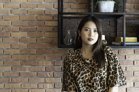A beautiful woman portrait. Asian teenager concept, with tiger line shirt in the vintage cafe.の写真素材