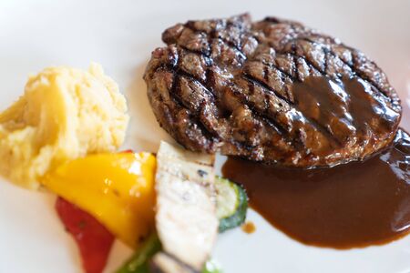 Close up. Delicious fresh beef steak with black pepper sauce dipping, on white dish, in luxury restaurant, steak food concept.の写真素材