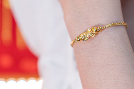 Luxury gold bracelet, Golden Dragon Pixiu or Pi Yao on arm background. Traditional of china for...