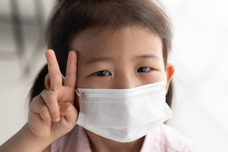 Asian child girl wearing a protection mask, to prevent virus infection or pollution.