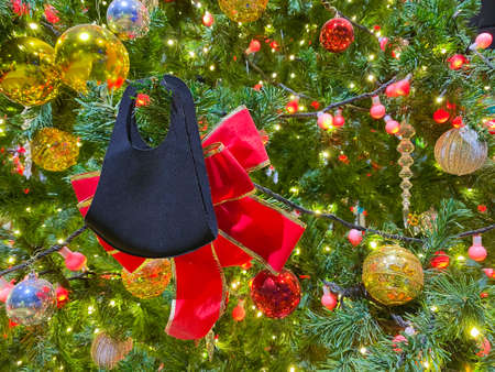 Christmas background with black mask and decorated christmas tree on blurred, sparkling and fairy background.の写真素材