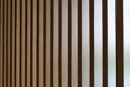 Close up. Seamless pattern of modern wall covering with light brown wooden slats. Background interior design.の写真素材