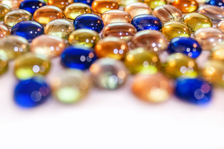 Transparent, glisten, colored glass stones on white background.
