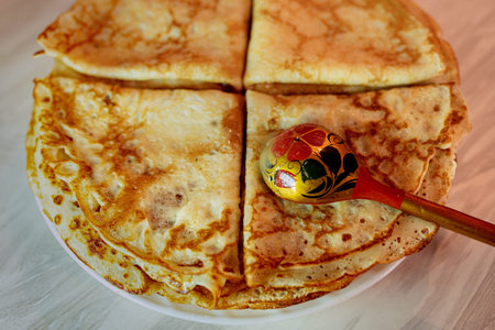 A plate of pancakes and a wooden spoon. Pancake day.