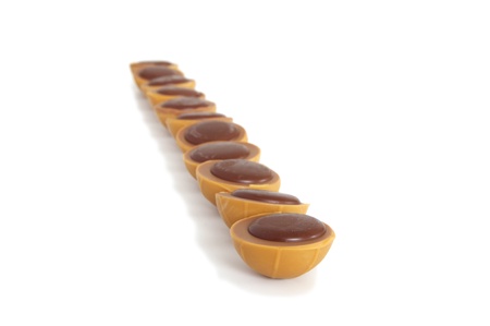 toffee chocolates arranged in single line on white backgroundの写真素材