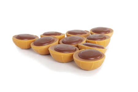 toffee chocolates arranged in a triangle on white backgroundの写真素材