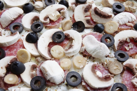 raw pizza with ham, olives and mushroomsの写真素材