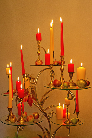 Darkroom. Glowing candles and apples stand in a candlestickの写真素材