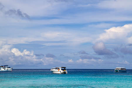 ships sail across the ocean against the cloudsの写真素材