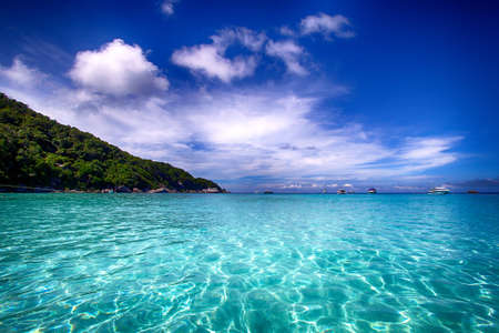 Asian rocky shore, emerald water and cloudsの写真素材