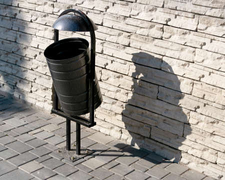 Brown urn in the park in bright light near a brick wallの写真素材