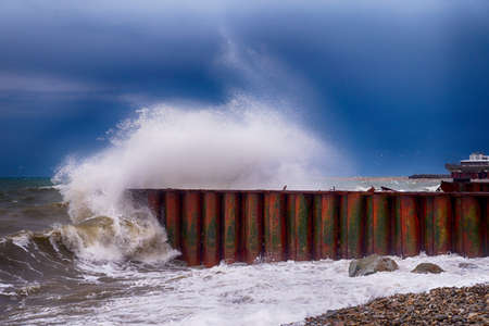 sea wave rock crush. Sea wave stone crash at metal breakwaterの写真素材