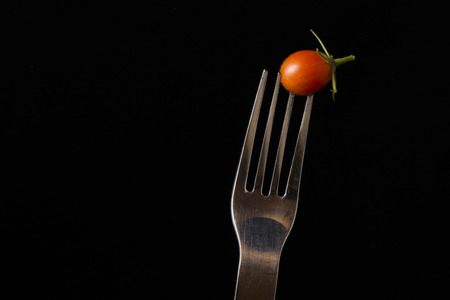 Fork and tomato in close upの写真素材