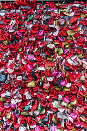 Colored padlocks hanging on a wall with writing and heartsの写真素材
