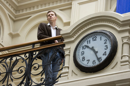 Portrait of the modern young man in an interior with hoursの写真素材