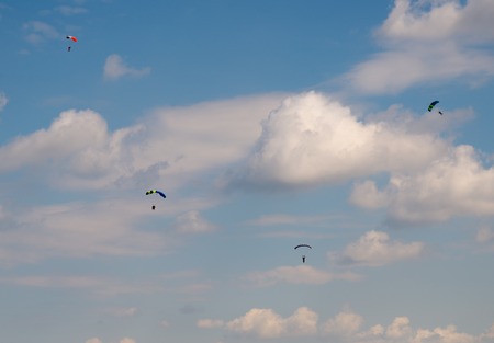 skydivers against the blue sky with white cloudsの写真素材