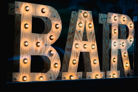 Vintage bar sign illuminated against a dark backgroundの写真素材