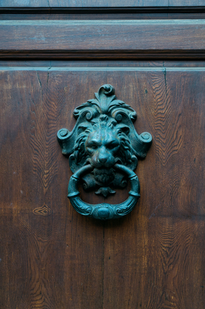 Architectural details -ancient door knoker with lion in Italyの写真素材