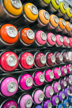 colorful cans of paint stand rows on a shelfの写真素材